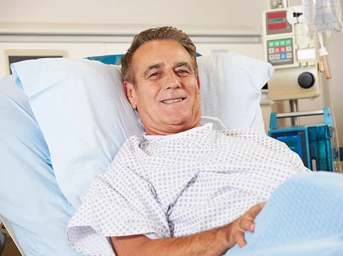 איש שוכב במיטת מדיקל שלו ומחייך